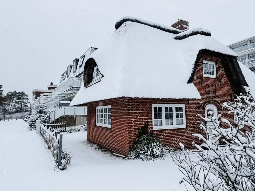 Verschneites Reetdachhaus in St. Peter-Ording im Winter